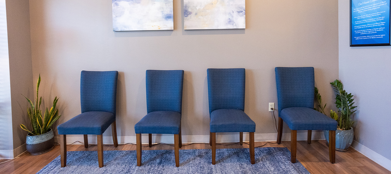 Four empty blue chairs in reception area of Marion dental office