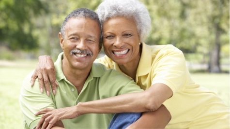 Senior man and woman hugging each other outdoors