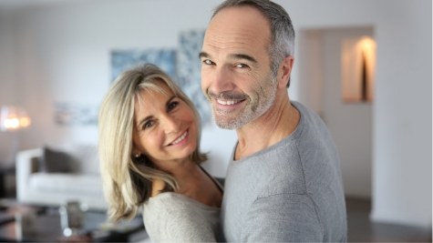 Older man and woman smiling in their living room