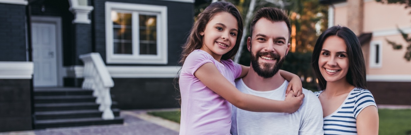 smiling family in front of house in Marion