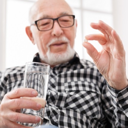 Man holding pill and glass of water for oral conscious sedation dentistry