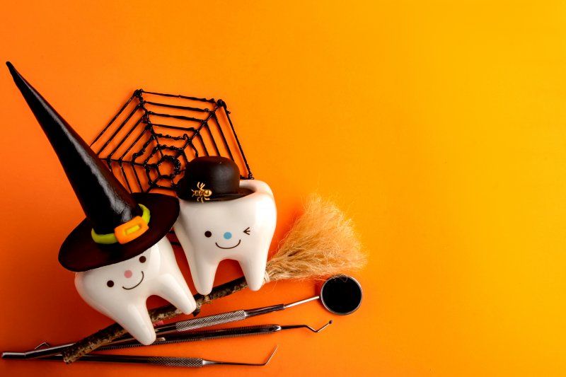 Smiling, Halloween-themed teeth set next to dental tools