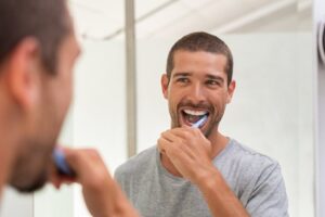 Man brushing his teeth with veneer-safe toothpaste